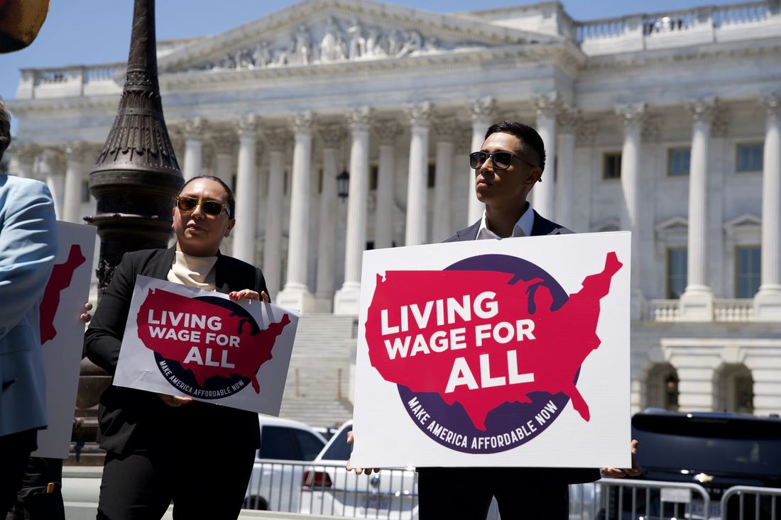 Supporters holding Living Wage For All signs at the U.S. Capitol